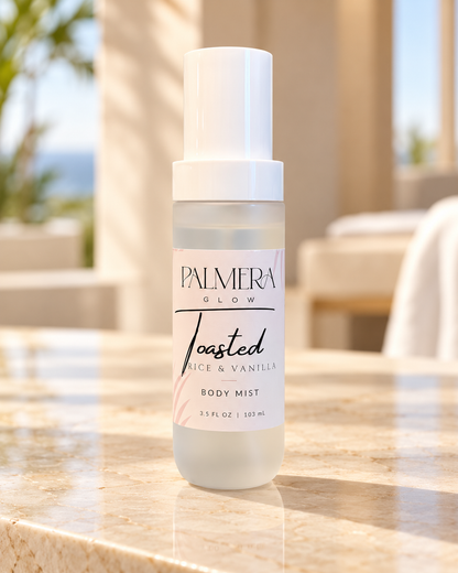 Palmera Glow Toasted Rice & Vanilla Body Mist on a sunlit stone ledge
